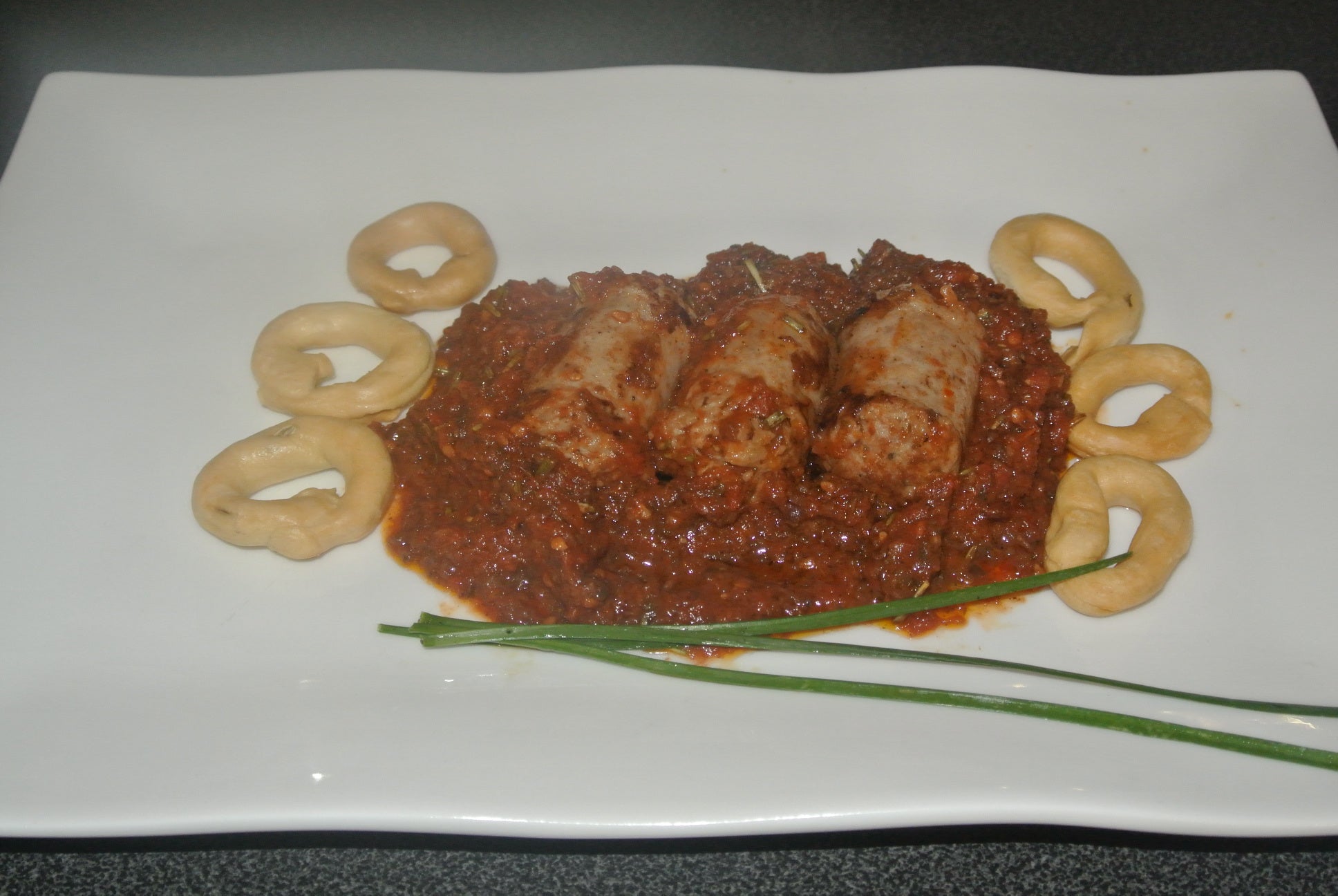 Bratwurst mit schwarzen Oliven